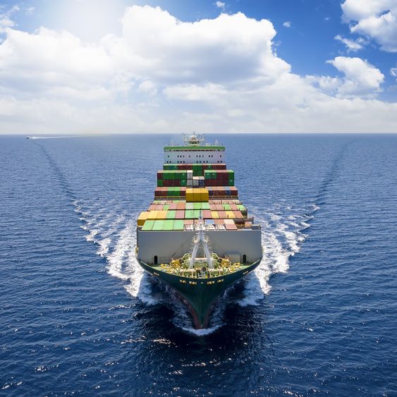 Aerial front view of a loaded container cargo vessel Aerial front view of a loaded container cargo vessel traveling over the ocean with good weather